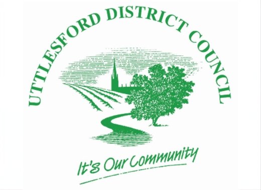 Green logo for Uttlesford District Council featuring a road, tree, buildings, and the slogan “It’s Our Community” below the illustration—a design that reflects the spirit of Uttlesford and resonates throughout its Council Chambers.