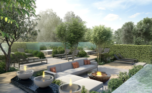 Modern outdoor patio with grey sofas, orange cushions, fire pits, lounge chairs, lush green trees, and shrubs surrounding a sunny social area with a water feature in the foreground—enhanced by discreet Garden Audio Systems that let you enjoy your favourite music while relaxing outdoors.