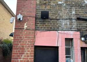Wall-mounted speaker and security camera installed on the exterior of EMCA Mosque